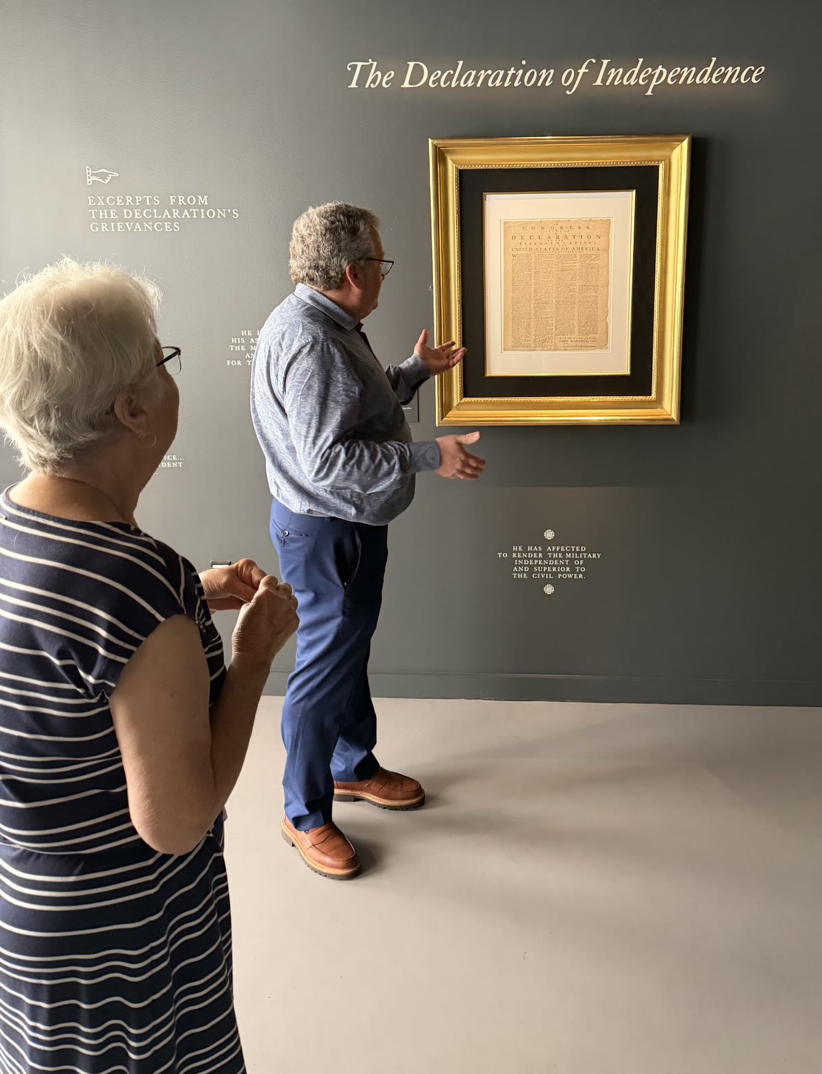 Seth Kaller showing Mom a framed printing of the Declaration of Independence at The Promise of Liberty exhibition